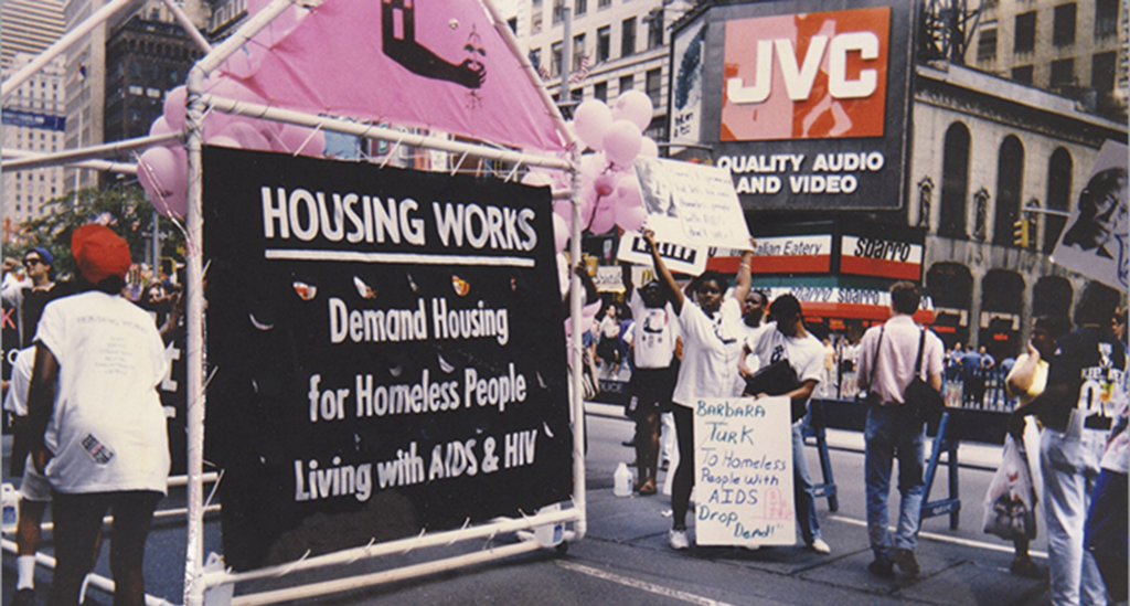 Image of a Housing Works banner demanding housing for homeless people living with HIV/AIDS, circa 1991